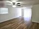 Another view of a bright living room with wood laminate flooring, ceiling fan and sliding door for lots of natural light at 6317 Buster Dr, Tampa, FL 33619