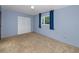Cozy blue bedroom with plush carpet, a window with natural light, and a closet at 6536 115Th Ln, Seminole, FL 33772