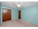 Bedroom with blue walls and carpeted floors, featuring two closets and ceiling fan at 6536 115Th Ln, Seminole, FL 33772