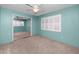 Bright bedroom with blue walls, carpeted floors, and shuttered windows; ceiling fan included at 6536 115Th Ln, Seminole, FL 33772