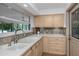 Cozy kitchen featuring stainless steel sink, stone tile backsplash, and wood cabinets and drawers at 6536 115Th Ln, Seminole, FL 33772