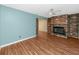Spacious living room with hardwood flooring, a brick fireplace, and ample natural light at 6536 115Th Ln, Seminole, FL 33772