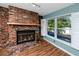 Inviting living room with a brick fireplace and natural light from a large window with white shutters at 6536 115Th Ln, Seminole, FL 33772