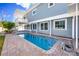 Beautiful in-ground pool with brick paver deck, set against the backdrop of a well-maintained two-story home at 6536 115Th Ln, Seminole, FL 33772