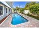 In-ground pool surrounded by a brick paver deck, and lush landscaping, creating a backyard oasis at 6536 115Th Ln, Seminole, FL 33772