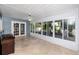 Bright sunroom with tile flooring, a ceiling fan, and large windows overlooking the lush backyard at 6536 115Th Ln, Seminole, FL 33772