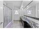 Bright bathroom features a long vanity with double sinks, dark cabinets, and a shower with lavender tub at 6801 Pinellas Point S Dr, St Petersburg, FL 33712