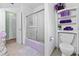 Neat bathroom with a shower featuring a lavender tub, matching bathmat, and a storage shelf with purple towels at 6801 Pinellas Point S Dr, St Petersburg, FL 33712
