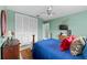 Comfortable bedroom with a ceiling fan, wood furniture, and bright-colored bedding at 6801 Pinellas Point S Dr, St Petersburg, FL 33712