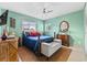 Comfortable bedroom with a ceiling fan, wood furniture, and bright-colored bedding at 6801 Pinellas Point S Dr, St Petersburg, FL 33712