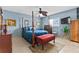 Stylish bedroom with a four-poster bed, ceiling fan, and ample natural light at 6801 Pinellas Point S Dr, St Petersburg, FL 33712