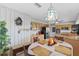 Cozy eat-in kitchen features warm cabinetry, granite counters, and a decorative pendant light fixture above the circular table at 6801 Pinellas Point S Dr, St Petersburg, FL 33712