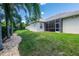 Spacious backyard with a screened-in porch and beautiful landscaping around the house at 6933 Cozumel Ct, Land O Lakes, FL 34637