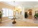Stately foyer with a decorative light fixture, round glass table, and beautiful tiled flooring at 6933 Cozumel Ct, Land O Lakes, FL 34637