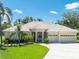Inviting single-story home featuring a well-kept lawn, tile roof, and an attached three-car garage at 6933 Cozumel Ct, Land O Lakes, FL 34637
