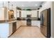 Modern kitchen with stainless steel appliances, white cabinetry, and granite countertops at 6933 Cozumel Ct, Land O Lakes, FL 34637