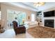 Comfortable living room with fireplace, built-in shelves, and large windows offering natural light at 6933 Cozumel Ct, Land O Lakes, FL 34637