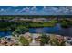 Aerial view of a home with water access and view of a nearby school on a sunny day at 699 Merlins Ct, Tarpon Springs, FL 34689