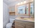 Bathroom featuring a vanity with decorative mirror and cabinet, toilet, and shower/tub with shower curtain at 699 Merlins Ct, Tarpon Springs, FL 34689