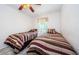 Cozy bedroom featuring twin beds with striped bedding and a ceiling fan at 699 Merlins Ct, Tarpon Springs, FL 34689