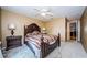 Bedroom featuring a decorative headboard, neutral walls, a ceiling fan, and doorway to other living areas at 699 Merlins Ct, Tarpon Springs, FL 34689