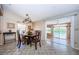 Dining area featuring a wooden table and chairs, with sliding glass doors providing scenic lake views at 699 Merlins Ct, Tarpon Springs, FL 34689