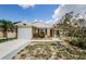 Inviting one-story home with a clean driveway, front yard garden, and stone detailing on the facade at 699 Merlins Ct, Tarpon Springs, FL 34689