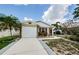 Pleasant one-story home features a well-kept driveway, garden space, and eye-catching stone decoration at 699 Merlins Ct, Tarpon Springs, FL 34689