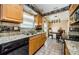 Efficient kitchen with stainless steel dishwasher and sink, granite countertops, and wooden cabinets at 699 Merlins Ct, Tarpon Springs, FL 34689