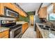 Well-lit kitchen with stainless steel appliances, granite countertops, and ample cabinet space at 699 Merlins Ct, Tarpon Springs, FL 34689