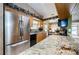 Bright kitchen featuring stainless refrigerator and appliances, granite countertops, and wood cabinets at 699 Merlins Ct, Tarpon Springs, FL 34689