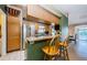 Charming eat-in kitchen with granite countertops, bar seating, stainless refrigerator, and tile flooring at 699 Merlins Ct, Tarpon Springs, FL 34689