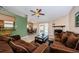 Inviting living room featuring a cozy fireplace, ceiling fan, and comfortable brown sofa at 699 Merlins Ct, Tarpon Springs, FL 34689