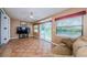 Bright sunroom with tile flooring, ceiling fan, television, and open access to the main residence at 699 Merlins Ct, Tarpon Springs, FL 34689
