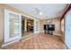 Bright sunroom with tile flooring, ceiling fan, and double doors leading to the kitchen and dining area at 699 Merlins Ct, Tarpon Springs, FL 34689