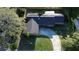 Aerial view of home showing solar panels on roof, concrete driveway, and mature landscaping at 7014 Doreen St, Tampa, FL 33617
