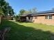 Spacious backyard featuring a fenced yard, greenery, and solar panels on the roof at 7014 Doreen St, Tampa, FL 33617