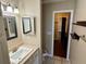 Bathroom featuring a single vanity, square mirrors and an adjacent toilet and doorway at 7014 Doreen St, Tampa, FL 33617