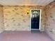 Covered front porch featuring a solid front door, lantern, and brick exterior at 7014 Doreen St, Tampa, FL 33617