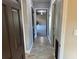 Hallway with tile floor leads to a room with painted concrete floors at 7014 Doreen St, Tampa, FL 33617