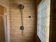 Tiled walk-in shower featuring updated fixtures and a window made of glass blocks at 7014 Doreen St, Tampa, FL 33617