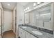 Bathroom featuring double sinks with granite countertop, large mirror, and walk-in shower at 764 W Bayshore Dr, Tarpon Springs, FL 34689
