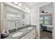 Bathroom featuring granite countertop, double sinks, large mirror, and walk-in shower at 764 W Bayshore Dr, Tarpon Springs, FL 34689
