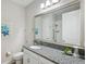Bathroom with a granite countertop, a toilet, vanity, and large mirror at 764 W Bayshore Dr, Tarpon Springs, FL 34689