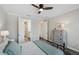 Bright bedroom featuring a ceiling fan, access to the bathroom, and a vintage-style dresser at 764 W Bayshore Dr, Tarpon Springs, FL 34689
