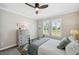 Well-lit bedroom featuring plantation shutters, a ceiling fan and vintage-style dresser at 764 W Bayshore Dr, Tarpon Springs, FL 34689