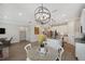Open-concept dining area with modern chandelier, adjacent to a kitchen and living room with neutral tones at 764 W Bayshore Dr, Tarpon Springs, FL 34689