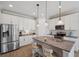 Bright kitchen with white cabinets, granite countertops, and a stainless steel refrigerator at 764 W Bayshore Dr, Tarpon Springs, FL 34689