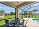 Covered lanai with outdoor seating, offering serene views of the pool and backyard at 764 W Bayshore Dr, Tarpon Springs, FL 34689