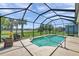 Screened-in pool area with a waterfall feature and views of the lush green lawn at 764 W Bayshore Dr, Tarpon Springs, FL 34689